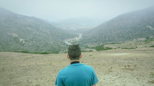 Rear view of man looking at mountains