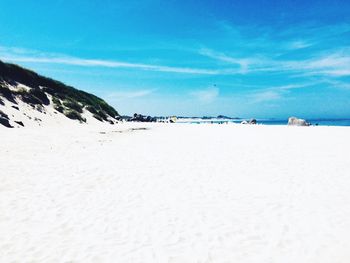 Scenic view of beach against blue sky