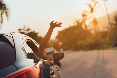 Woman peeking hand from car window