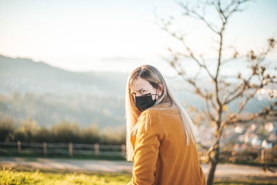 Portrait of woman against tree and sky