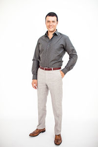 Portrait of young man standing against white background