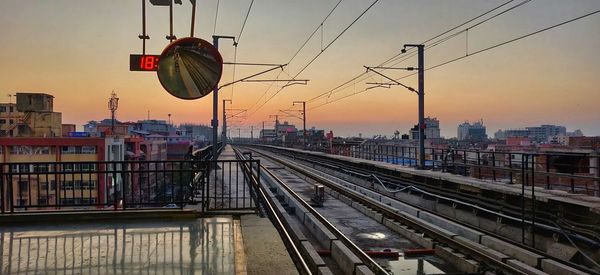 Train at railroad station in city against sky