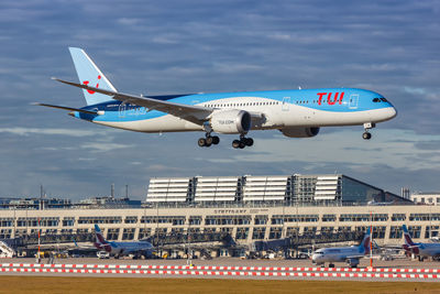 Airplane flying over city against sky