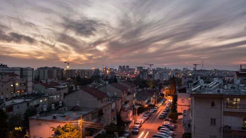 High angle view of illuminated cityscape against sky at sunset