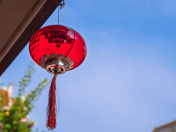 Low angle view of lantern hanging against blue sky