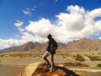 Full length of man looking at mountains against sky