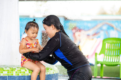 Bangkok, thailand, jun 7, 2020 - asian mom and her daughter in swimming suit playing together