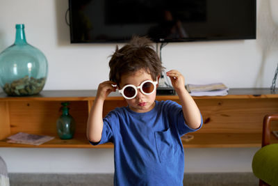 Portrait of young woman wearing sunglasses while sitting at home