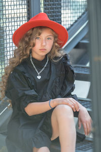 Portrait of young woman sitting in hat