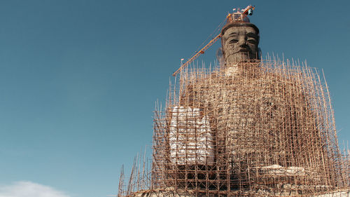 Low angle view of large buddha statue during construction