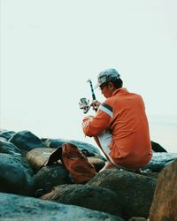 Man playing in water against sky
