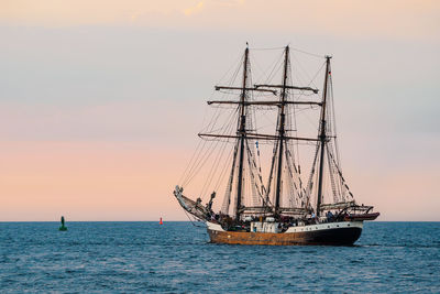 Sailboat sailing on sea against sky during sunset