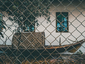 Chainlink fence against building seen through window