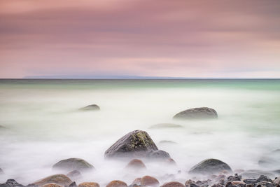 Long exposure sunset photo at baltic sea beach. purple horizon