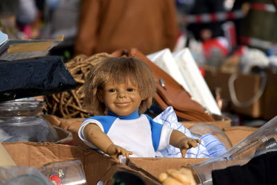 Doll in cardboard box at flea market for sale