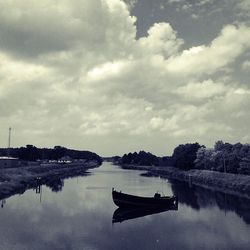 Boats in sea against cloudy sky