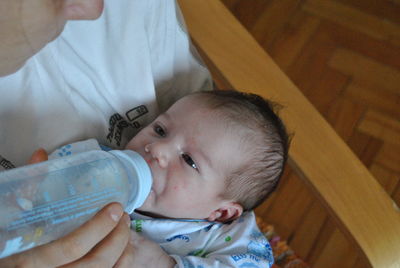 Close-up of mother feeding baby at home