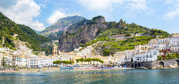 Panoramic view of small haven of amalfi village with turquoise sea and colorful houses on slopes 