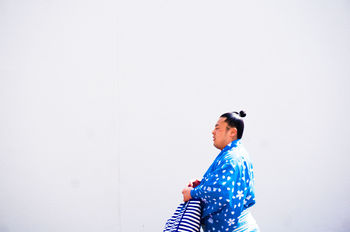MAN STANDING AGAINST WALL