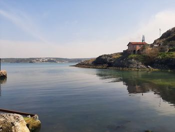 Scenic view of sea by buildings against sky