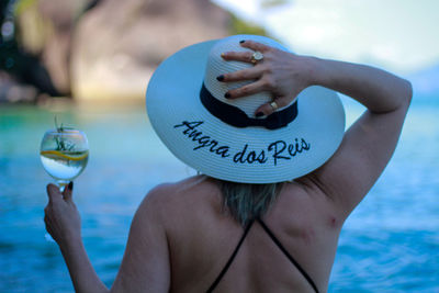 Midsection of person holding ice cream against sea