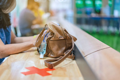 Midsection of woman sitting on table at store