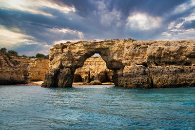 Rock formations by sea against sky