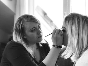 Artist applying make-up on woman face