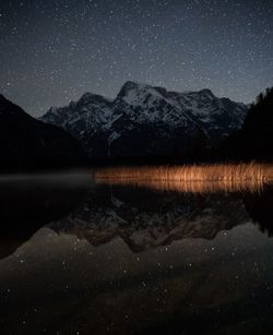 Reflection of mountains in lake during night