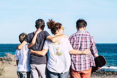 Rear view of family standing at beach