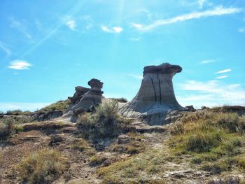 Built structure on landscape against blue sky