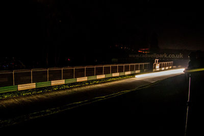 Light trails on road against sky at night