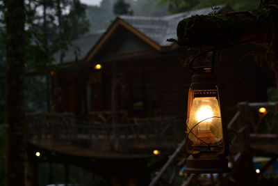 Close-up of old oil lamp hanging against house