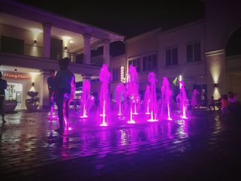 People standing in illuminated city at night