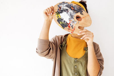 Midsection of woman holding ice cream against white background