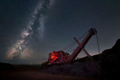 Low angle view of abandoned crane against sky at night