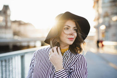 Portrait of young woman standing in city