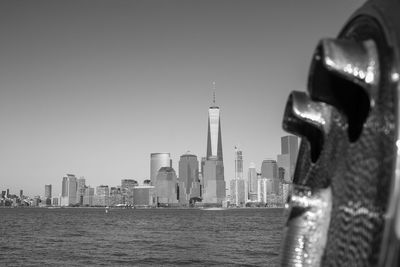 River by one world trade center with cityscape against sky