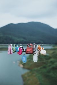 Close-up of padlocks hanging on metal against sky