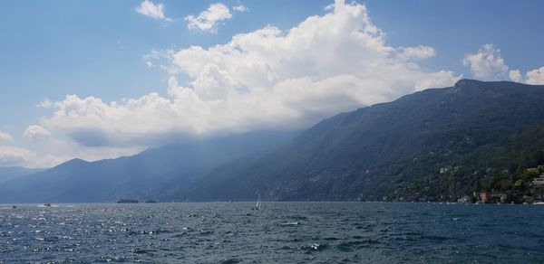 Scenic view of sea and mountains against sky