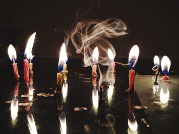 Close-up of burning candles on table