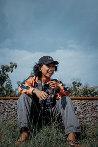 Young man using smart phone against sky