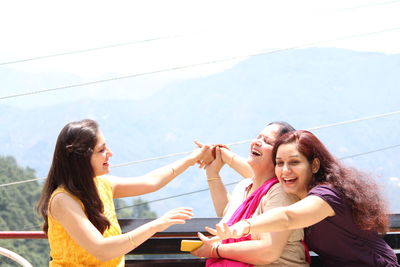 Woman smiling friends against sky