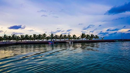 Scenic view of swimming pool by lake against sky