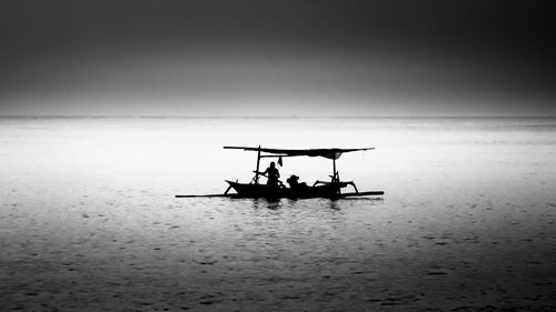 Silhouette ship in sea against sky