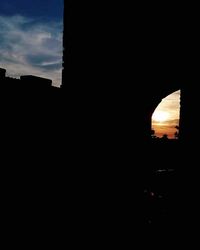 Silhouette of building against sunset sky