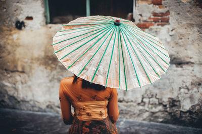 Rear view of woman with umbrella in old town