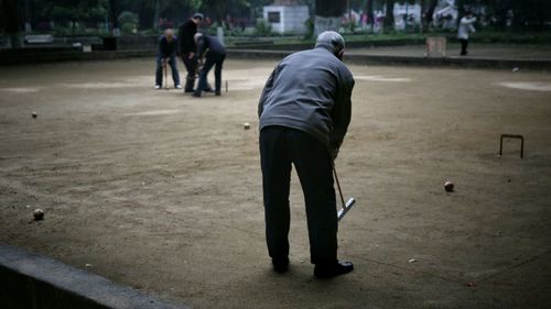 People playing croquet on ground