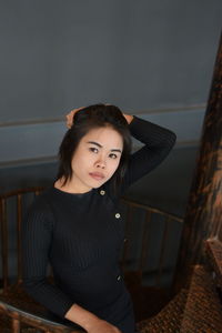 High angle portrait of beautiful woman standing on steps against wall