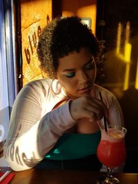 Young woman drinking glass at restaurant